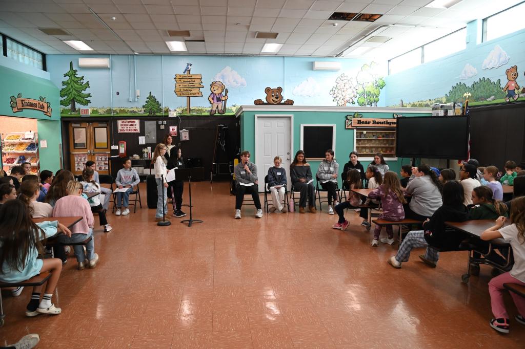 students speaks into microphone in a brightly painted room.